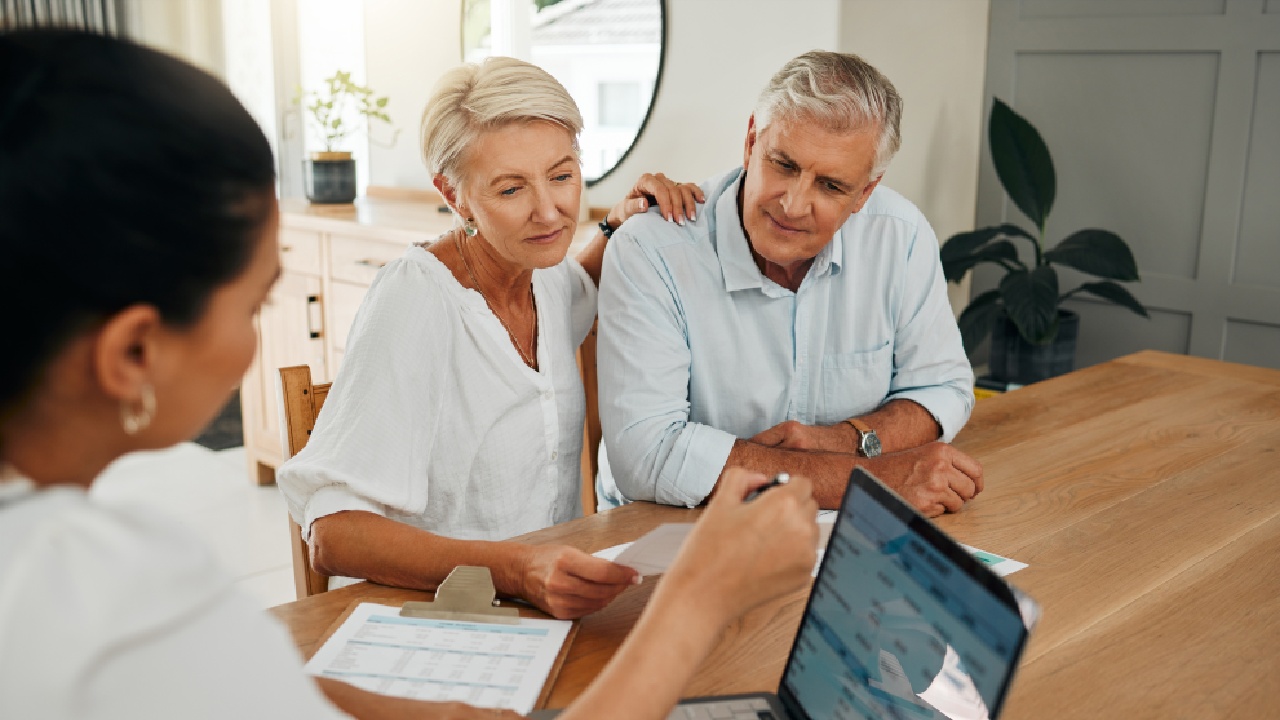 Older couple meeting with a financial advisor to discuss retirement planning—exploring whether they should set up an SMSF for retirement.