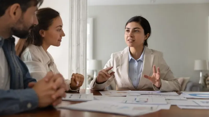 Accountant advising business owners during a financial planning meeting, discussing strategies to scale a business, improve cash flow, and increase profits.